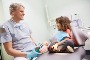 Zahnarztpraxis in Ehrenfeld, Kinderbehandlung. Dr. dent. Helge Kaufhold erklärt richtiges Zähneputzen.